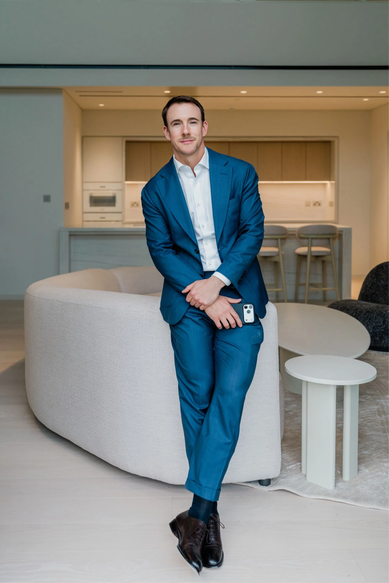 Liam Jeffrey in a blue suit inside an apartment