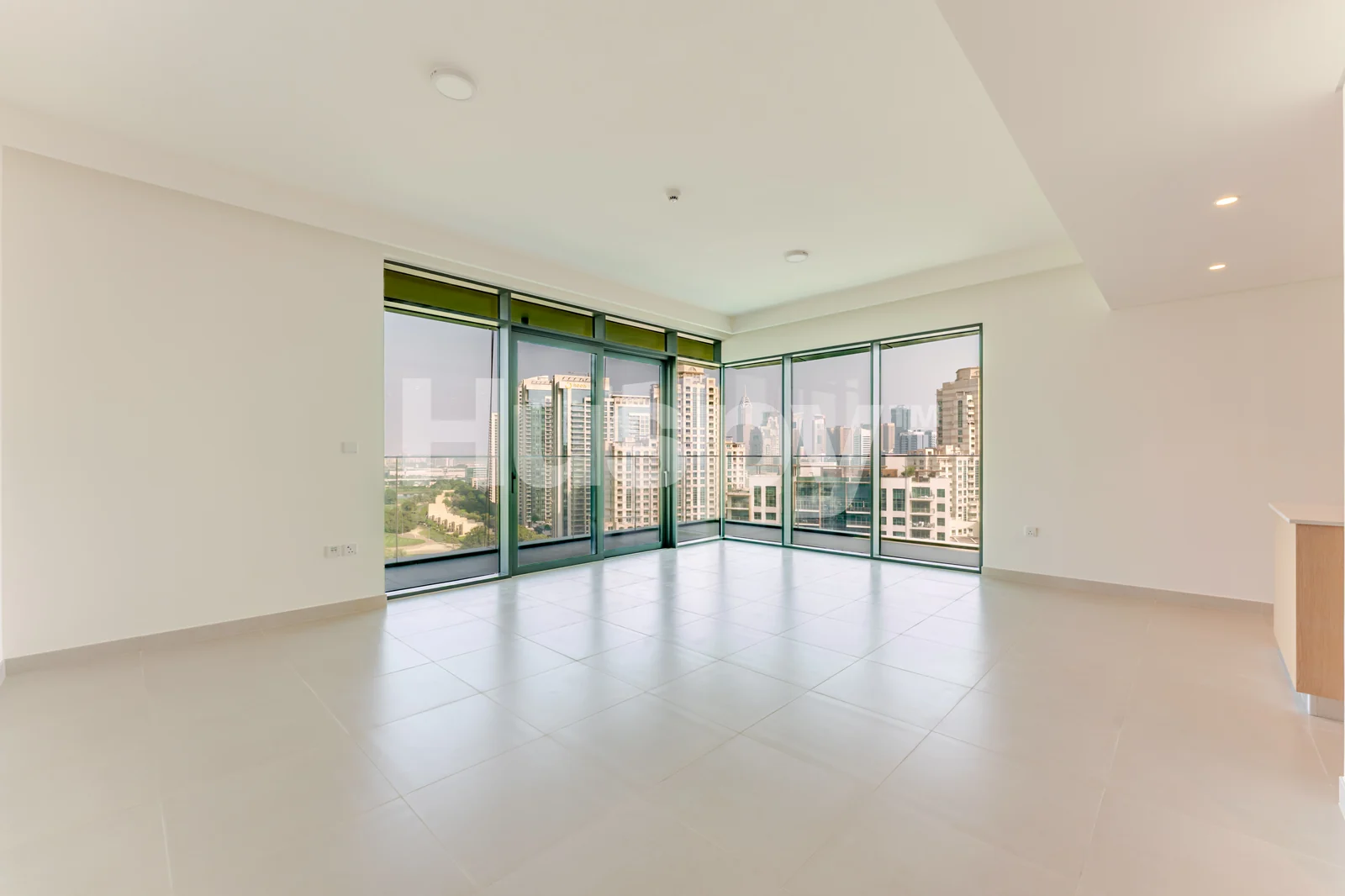 Open living room with corner windows and balcony doors