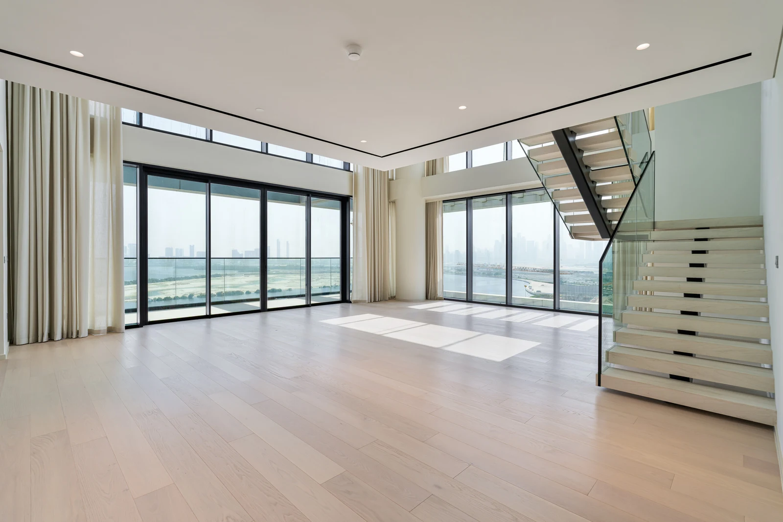 Living room with full-height windows overlooking Dubai Creek