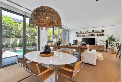 Dining table beside full-height garden windows
