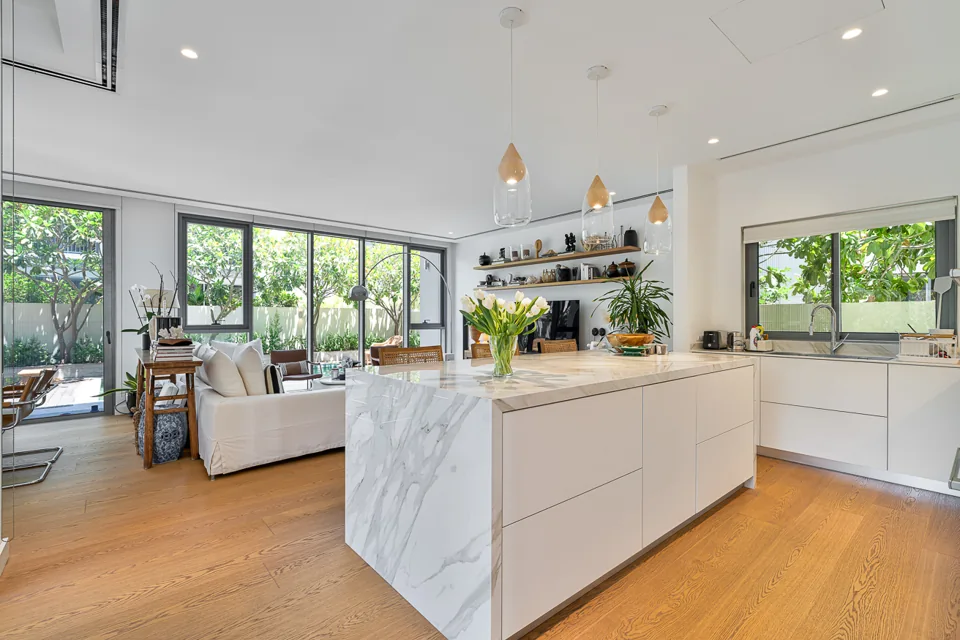Open-plan kitchen with stone island and views towards the pool