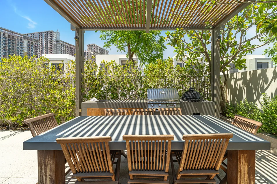 Outdoor dining beneath a timber pergola beside the garden