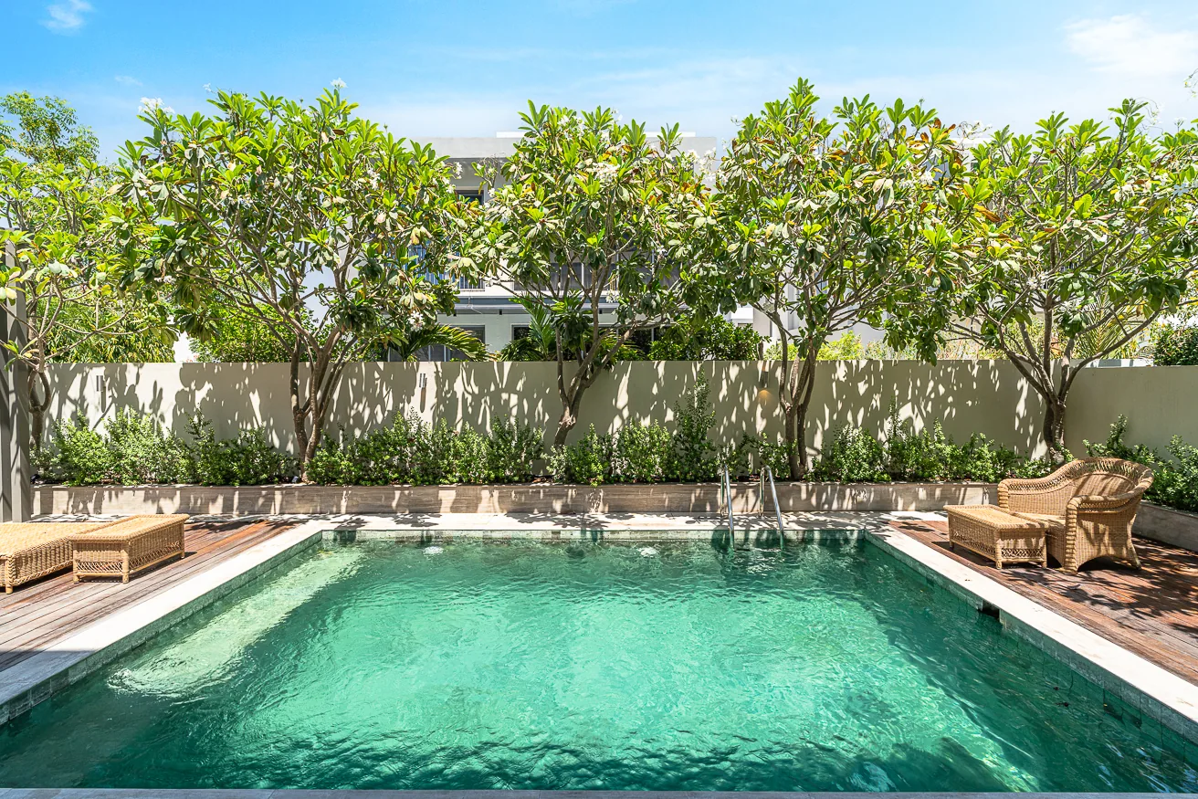 Sunlight on the private pool, framed by a lush garden