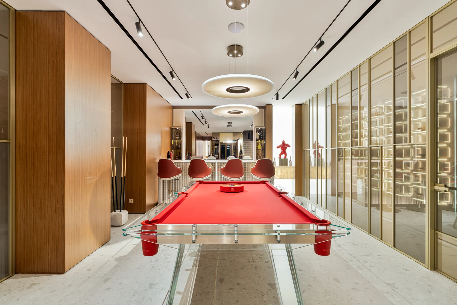 Billiards lounge with a red table and glass-fronted wine storage