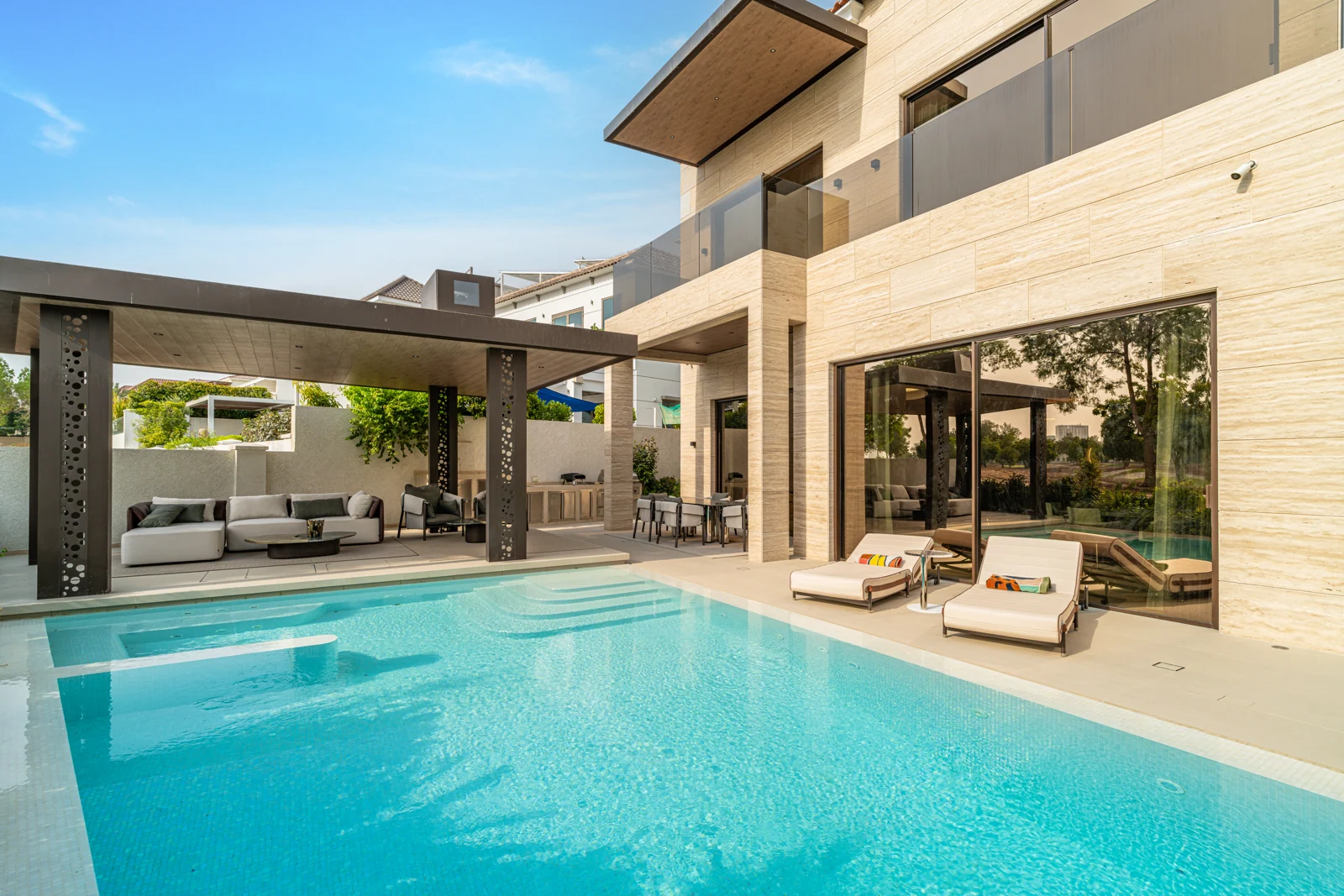 Turquoise swimming pool, shaded lounge and stone villa at Wildflower